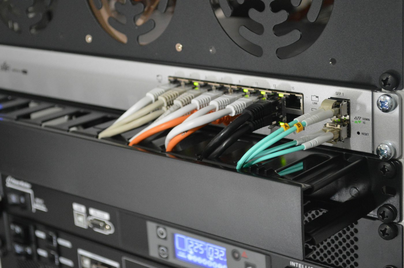 Fiber and patch cables connected to rack-mounted network equipment