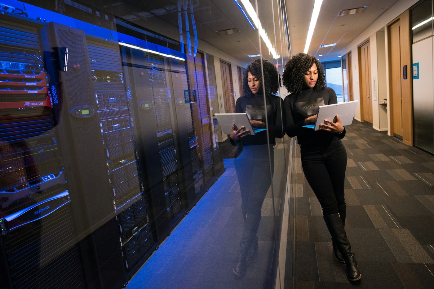 Technicians with laptops in a data center aisle